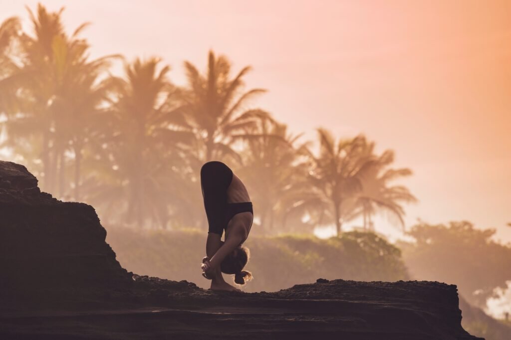 Indonesia, Bali, woman practising yoga at the coast at twilight