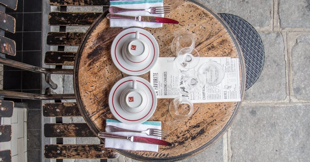 Top view of a vintage cafe table setting in Paris with wooden chairs and elegant tableware.