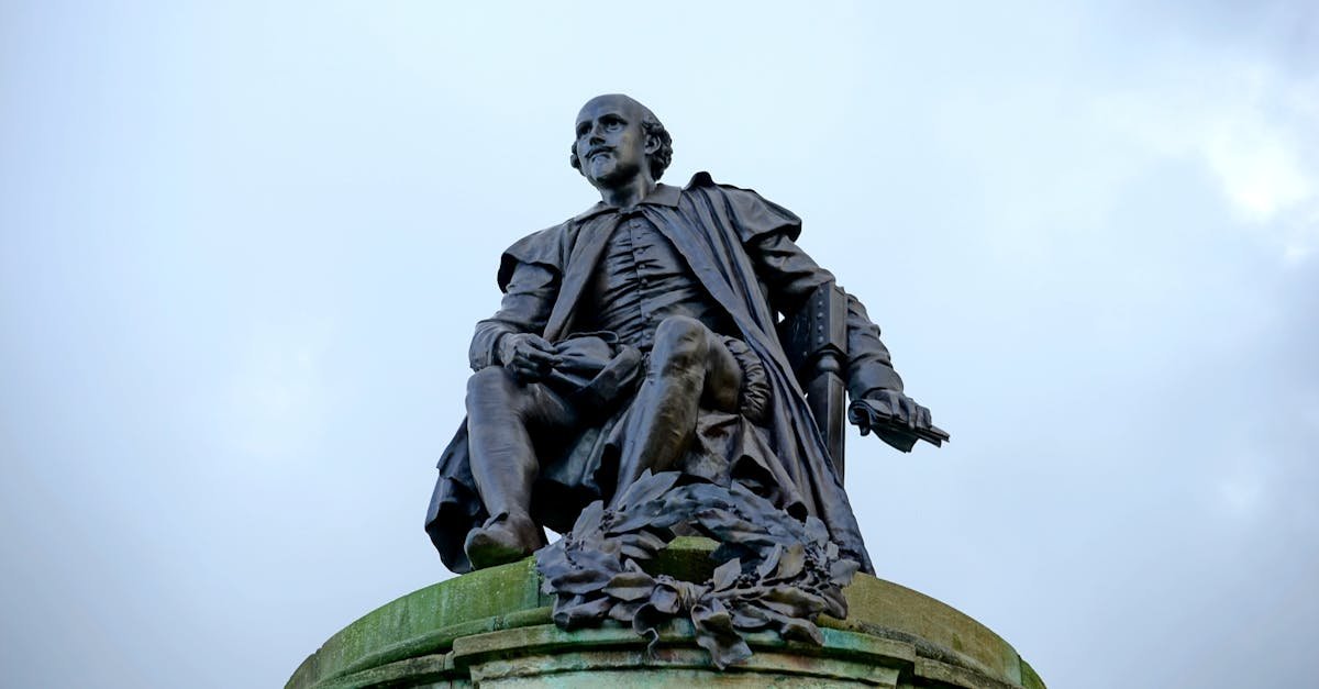 Statue of William Shakespeare in Stratford-upon-Avon, England against a cloudy sky.