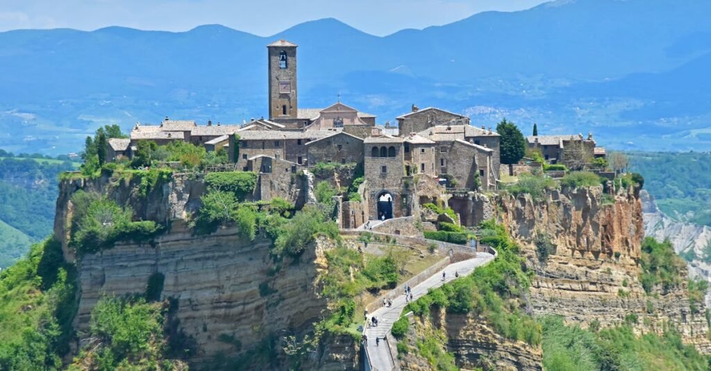 Scenic view of Civita di Bagnoregio perched on a cliff with mountain backdrop.