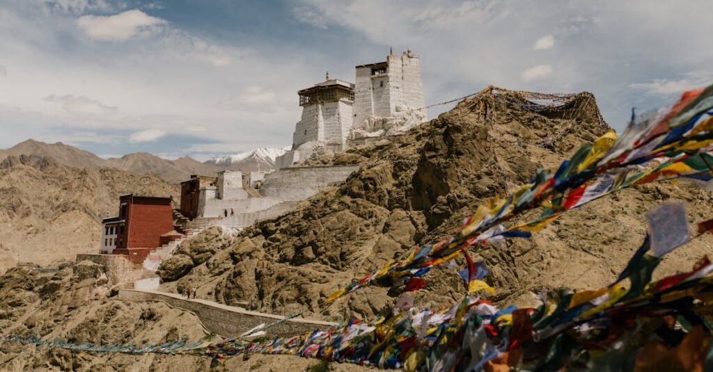 Stunning view of Namgyal Tsemo Monastery in the Himalayas with prayer flags waving in the wind.